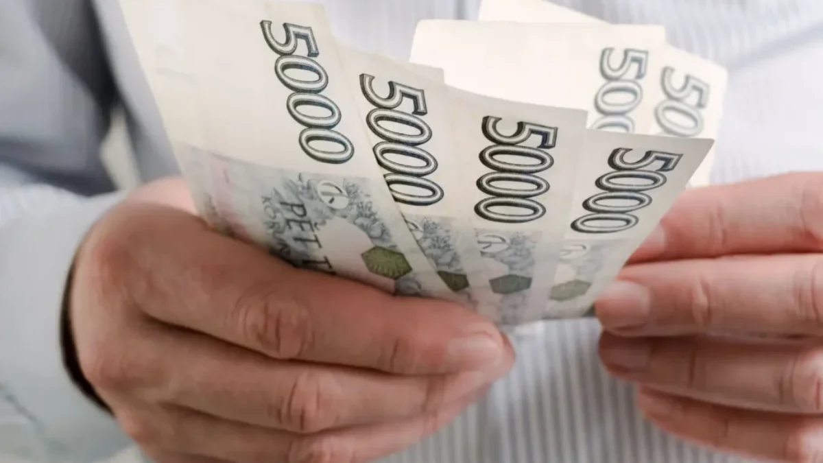 Detail rukou s českými pětitisícikorunovými bankovkami