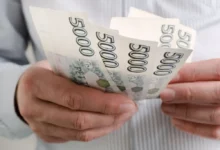 Detail rukou s českými pětitisícikorunovými bankovkami