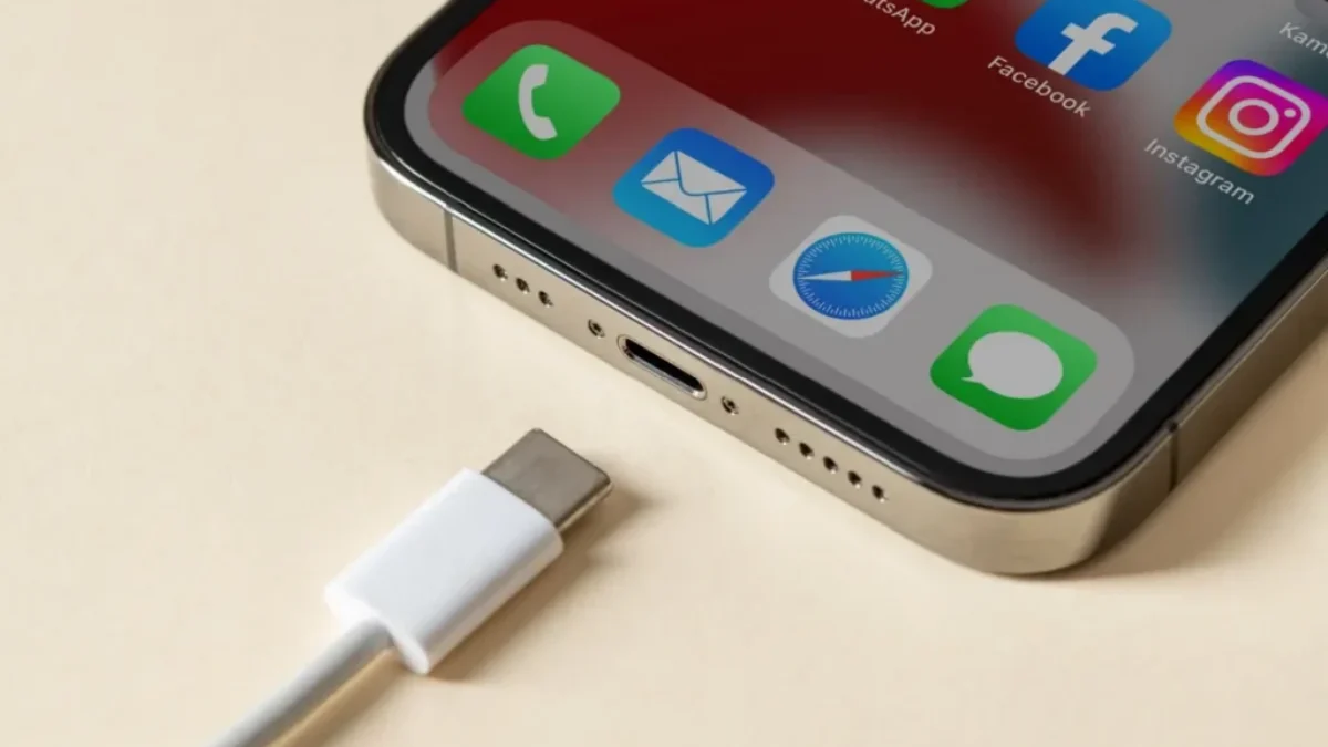 Detail nabíjecího konektoru chytrého telefonu s ikonami aplikací na displeji