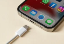Detail nabíjecího konektoru chytrého telefonu s ikonami aplikací na displeji