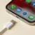 Detail nabíjecího konektoru chytrého telefonu s ikonami aplikací na displeji