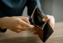Muž drží otevřenou prázdnou peněženku