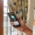 Ruka drží telefon se zobrazenou předpovědí počasí a ikonou slunce