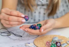 Žena drží astrologické kostky nad horoskopickým kolem na stole