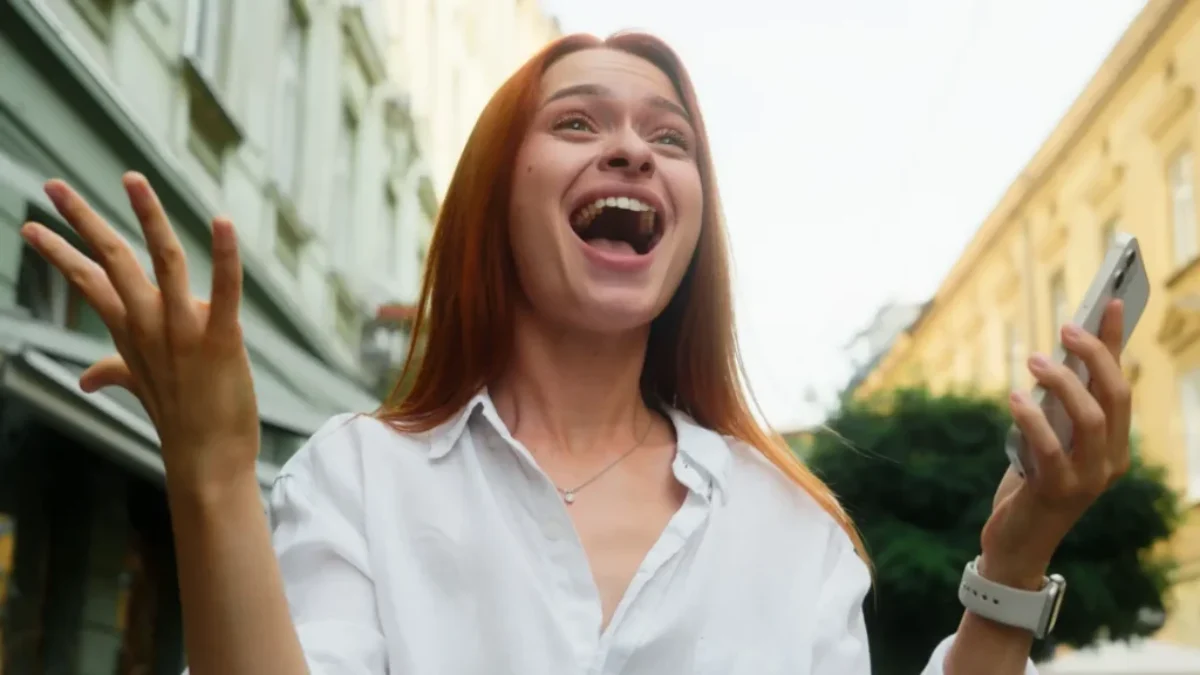 Žena v bílé košili se tváří velmi šťastně