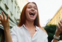 Žena v bílé košili se tváří velmi šťastně