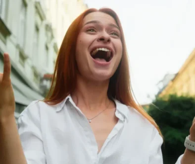 Žena v bílé košili se tváří velmi šťastně