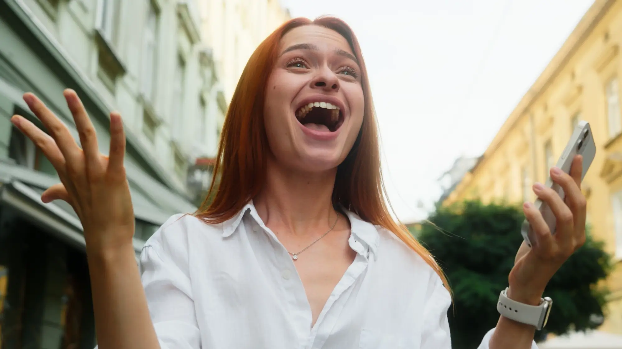 Žena v bílé košili se tváří velmi šťastně