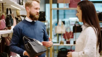 Prodavač prodává ženě luxusní kabelku