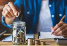 Muž sype peníze do sklenice