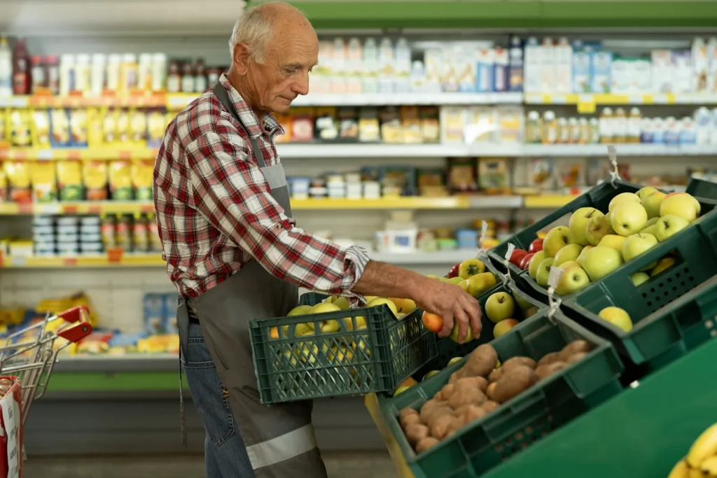 Senior doplňující ovoce v supermarketu