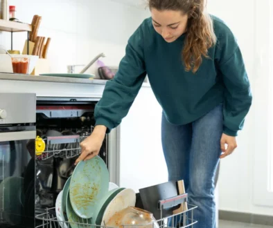 Dívka dává nádobí do myčky