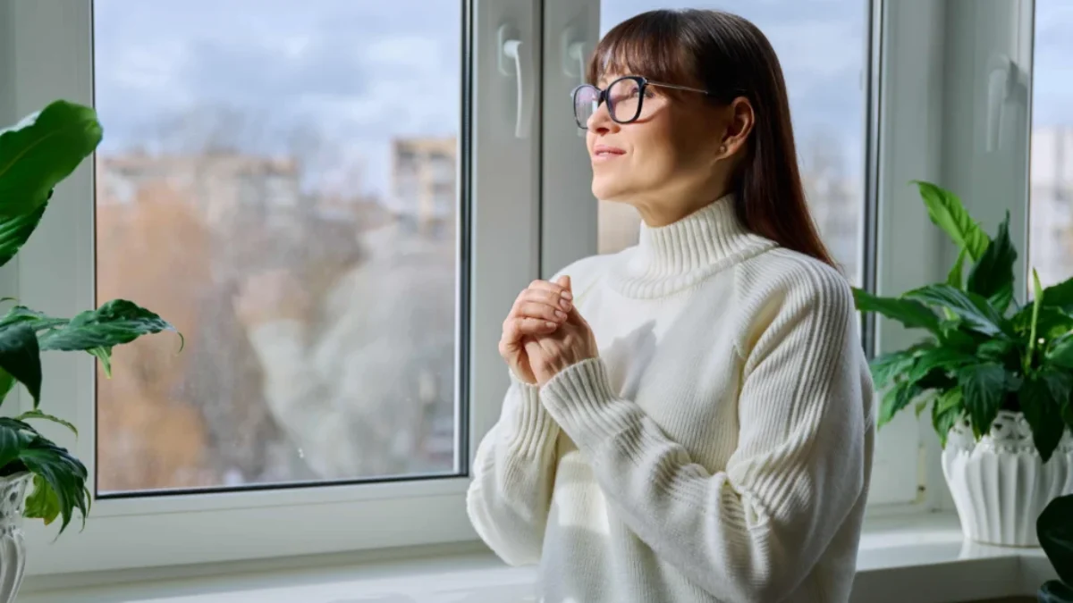 žena ve svetru u okna