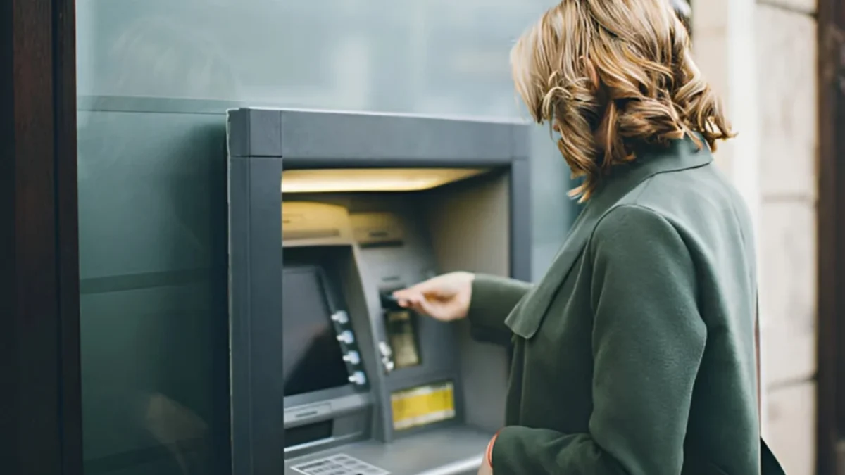 žena vybírá peníze z bankomatu