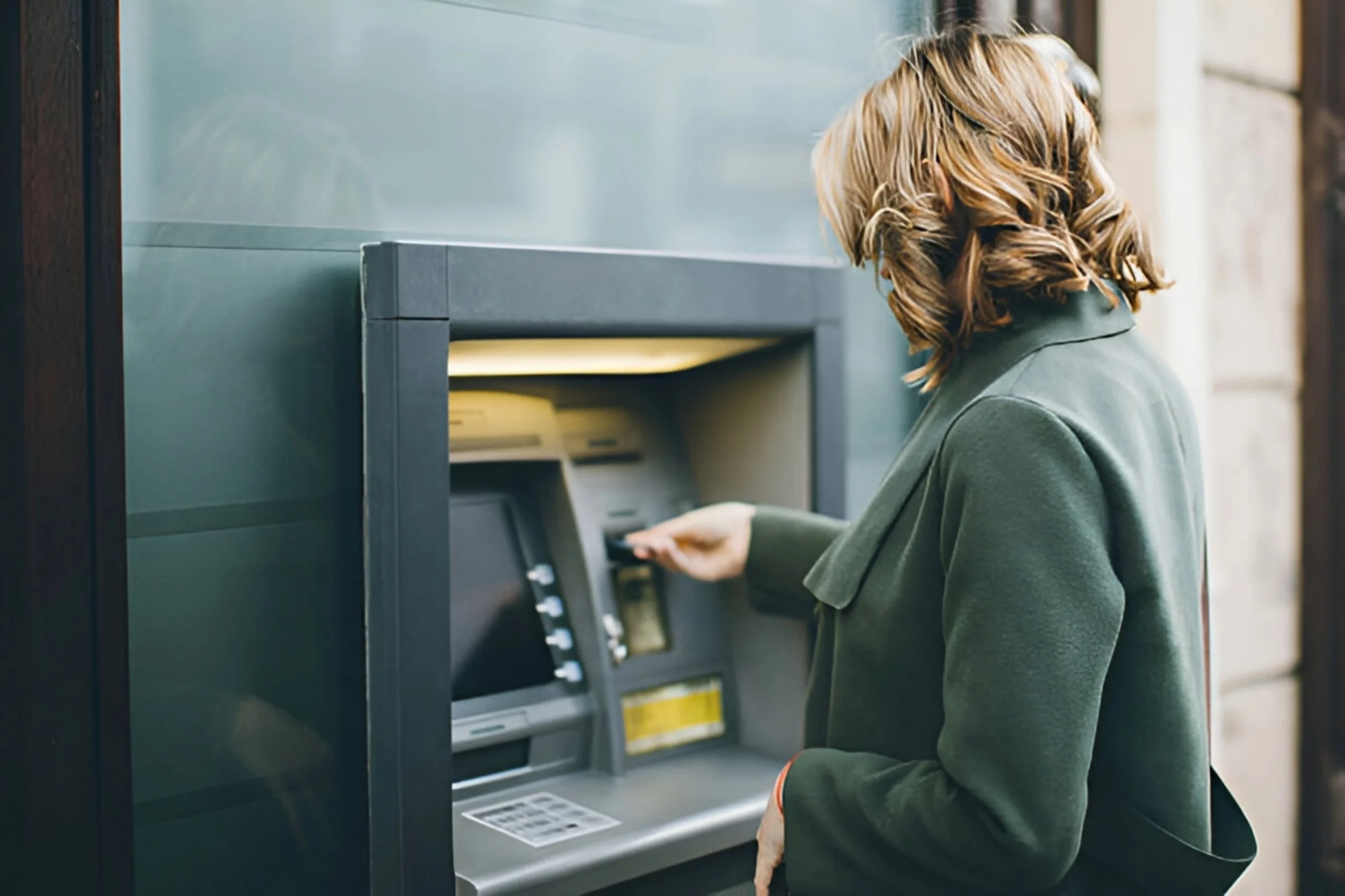 žena vybírá peníze z bankomatu