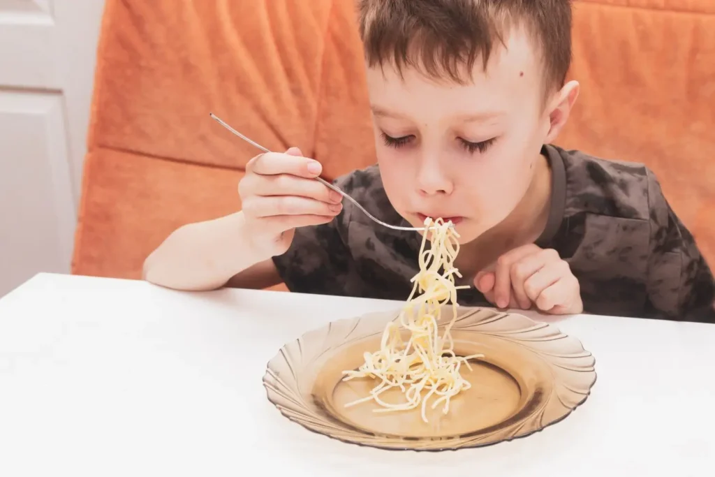 - ByznysDeník Malý chlapec obědvá suché těstoviny