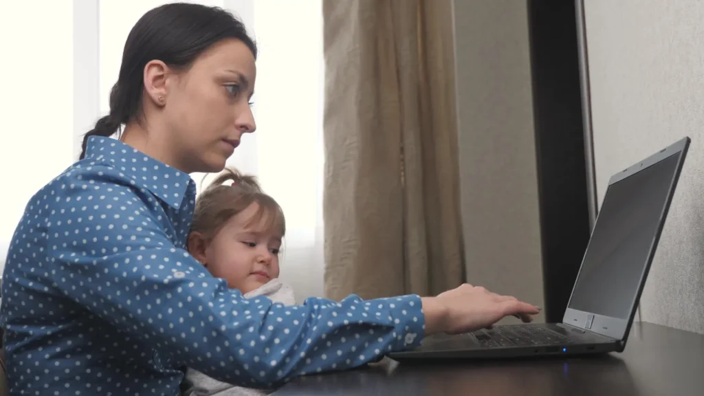 - ByznysDeník Matka pracuje u počítače, zatímco se stará o dceru