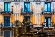 Euro mince se starým domem v pozadí