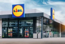 Pohled na vstupní část moderní prodejny Lidl s velkým logem a skleněnou fasádou