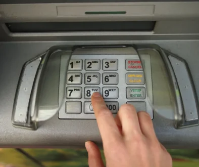 Ruka zadává PIN na bankomatu
