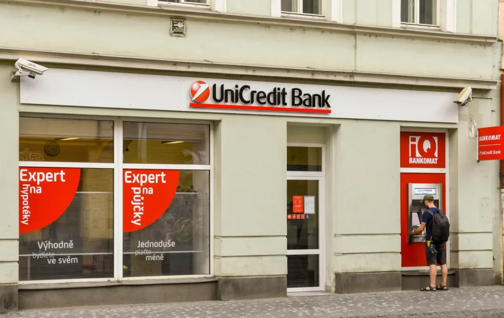 Muž vybírá z bankomatu Unicredit