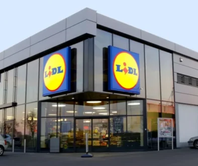 Moderní prodejna Lidl s prosklenou fasádou a výrazným logem na dvou stranách budovy.
