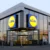 Moderní prodejna Lidl s prosklenou fasádou a výrazným logem na dvou stranách budovy.