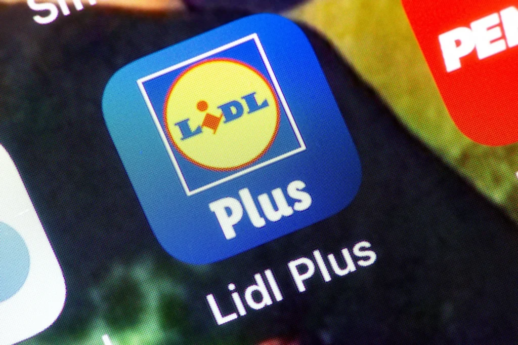 - ByznysDeník Detailní záběr ikony mobilní aplikace Lidl Plus na displeji telefonu.