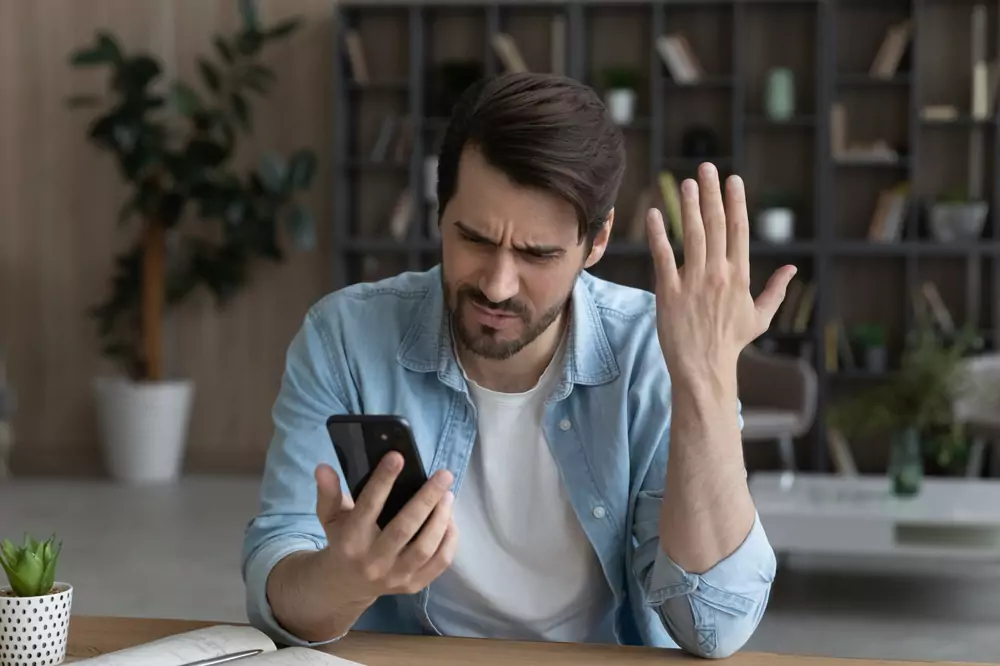 muž s problematickým telefonem v ruce