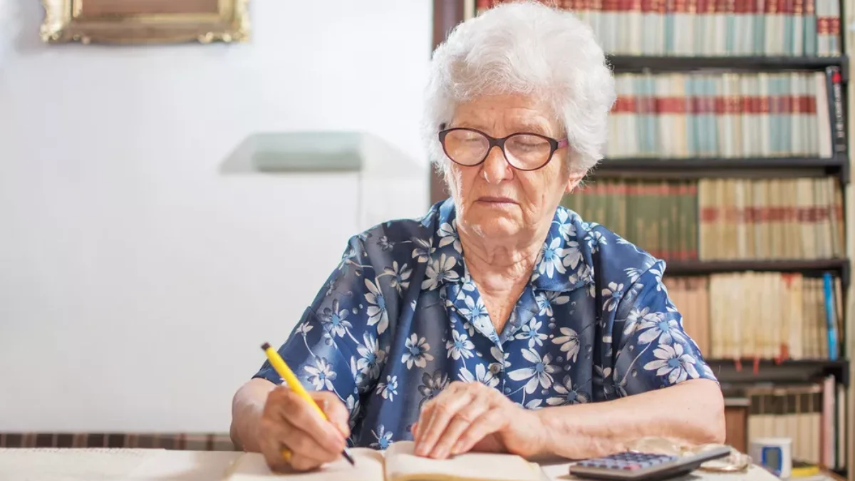 Pobíráte státní dávky sociální podpory? Co se pro vás změní s příchodem „superdávky“? Starší žena zapisující do sešitu financí