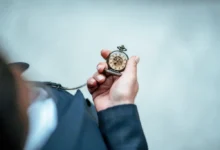 Muž drží kapesní hodinky