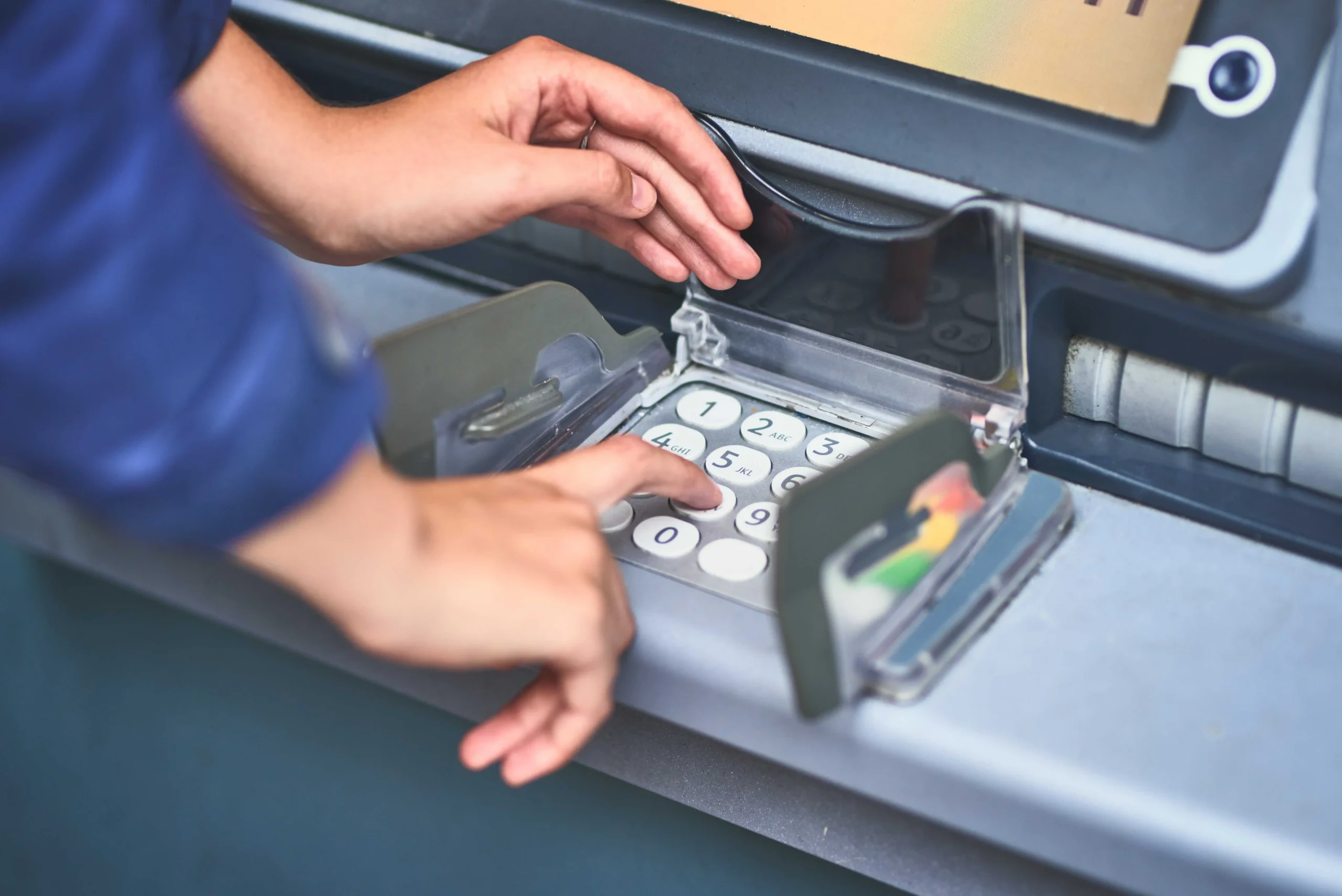 Žena zadává PIN do bankomatu