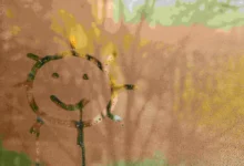 Sluníčko namalované na oroseném okně