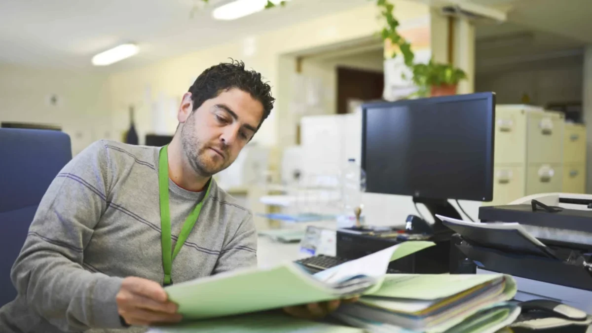 Mezi platy státních úředníku existují propastné rozdíly Muž čte složku s dokumenty