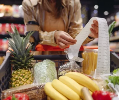 Žena porovnává ceny a kontroluje účtenku po nákupu