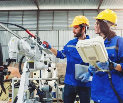 Muž a žena v hale s pracovním robotem.