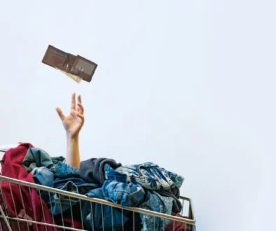 Nákupní košík plný oblečení a prázdná peněženka