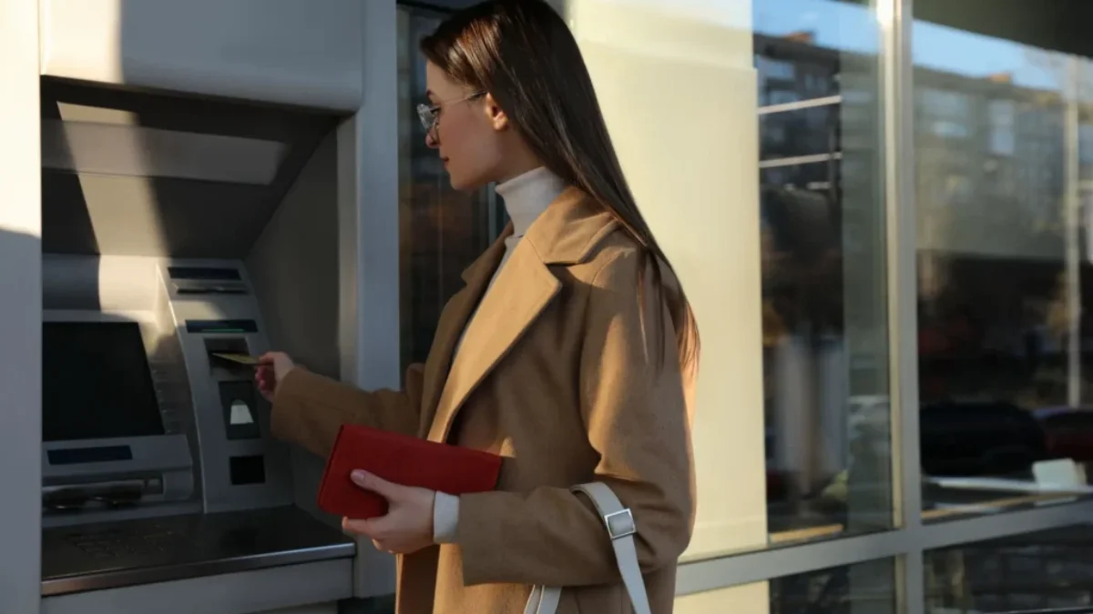 žena si vybírá peníze z bankomatu