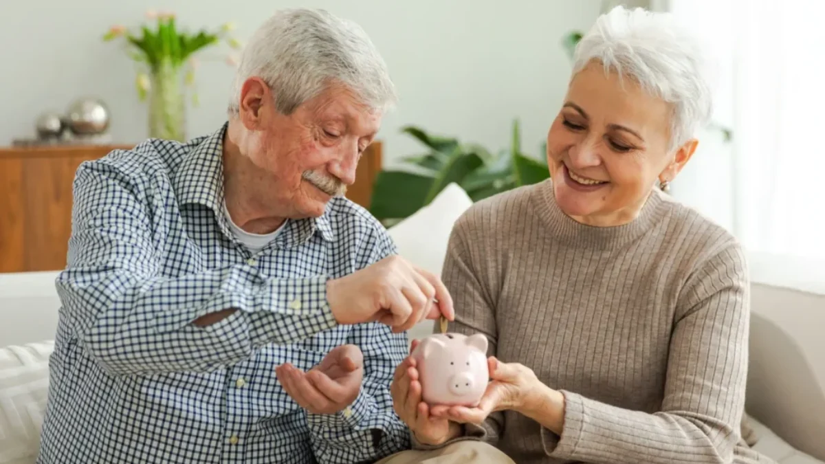Dva důchodci hází peníze do kasičky