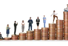 Lidé různých profesí stojí na komínku z mincí